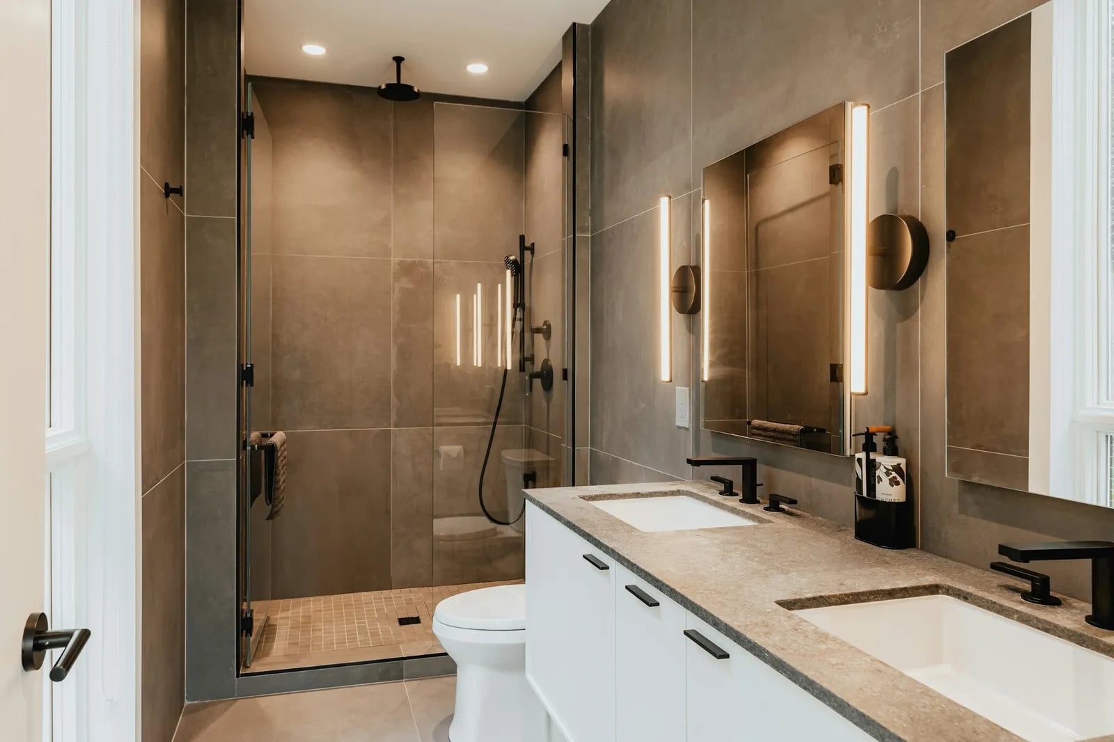 Salle de bain moderne avec douche vitrée, WC et double vasque